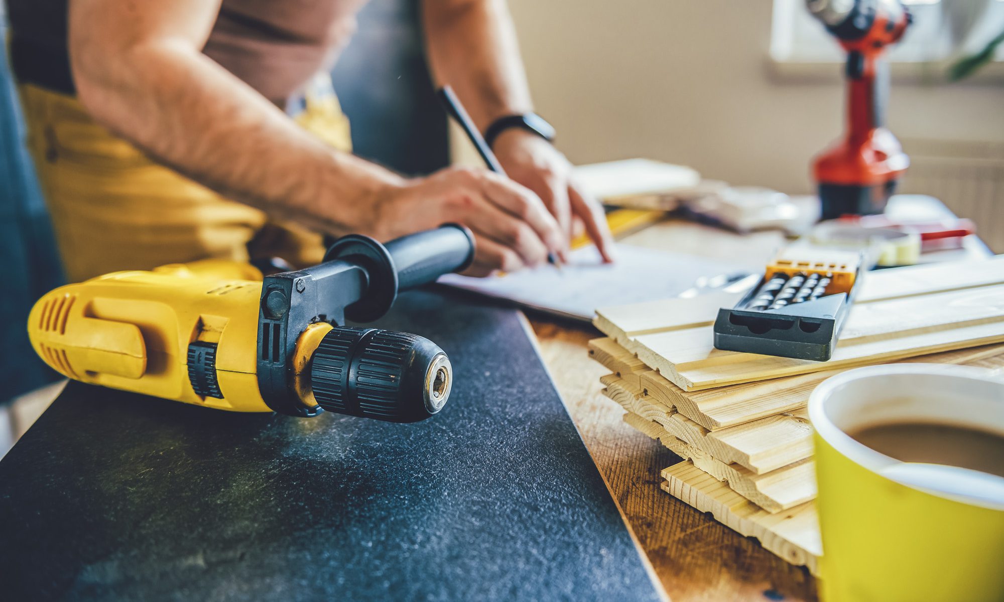 Power drill and Man making draft plan in the background